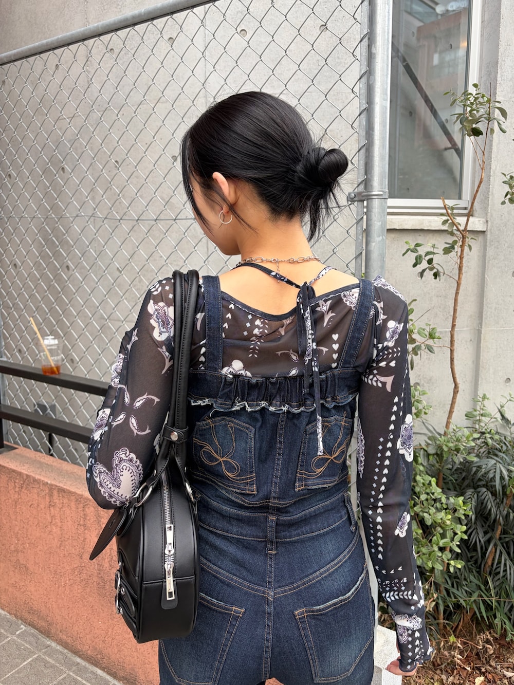 ブラック系のハンドバッグ、ブルー系のサロペット/オーバーオール、ブルー系のTシャツ/カットソーを着用したレディースの春コーディネートの5枚目の写真