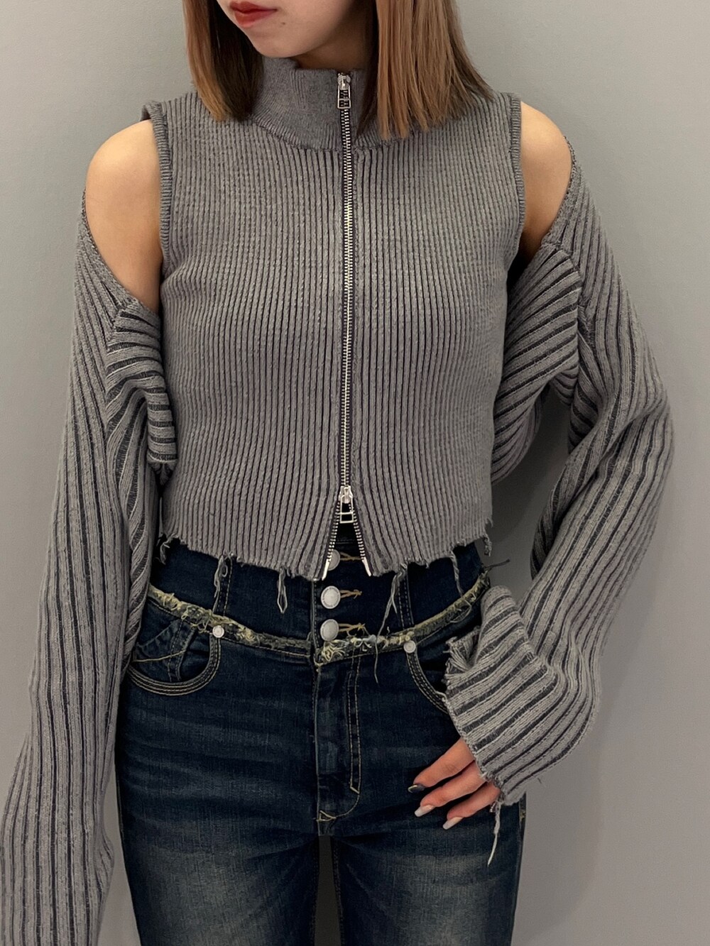 ブルー系のデニムパンツ、ブラック系のブーツ、グレー系のニット/セーターを着用したレディースの秋コーディネートの6枚目の写真