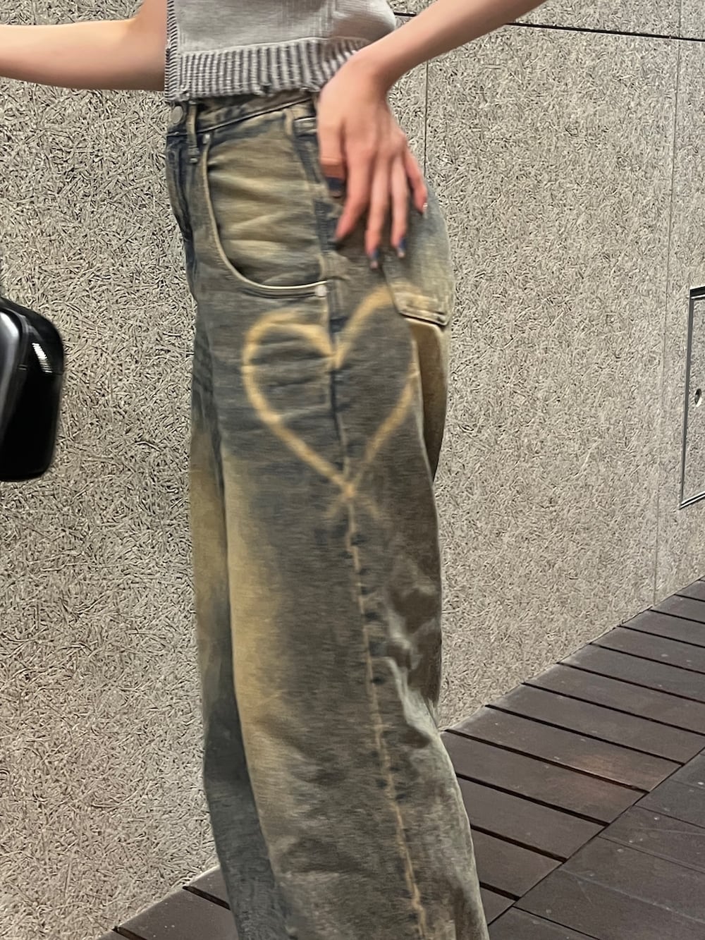 グレー系のタンクトップ、ブルー系のデニムパンツ、ブラック系のハンドバッグを着用したレディースの春コーディネートの5枚目の写真