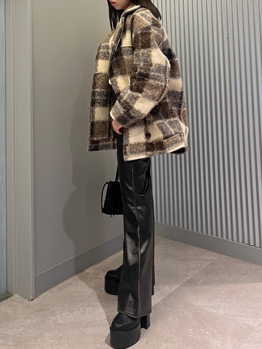 ブラック系のその他パンツ、シルバー系のブーツ、ブラック系のショルダーバッグを着用したレディースの秋コーディネートの2枚目の写真