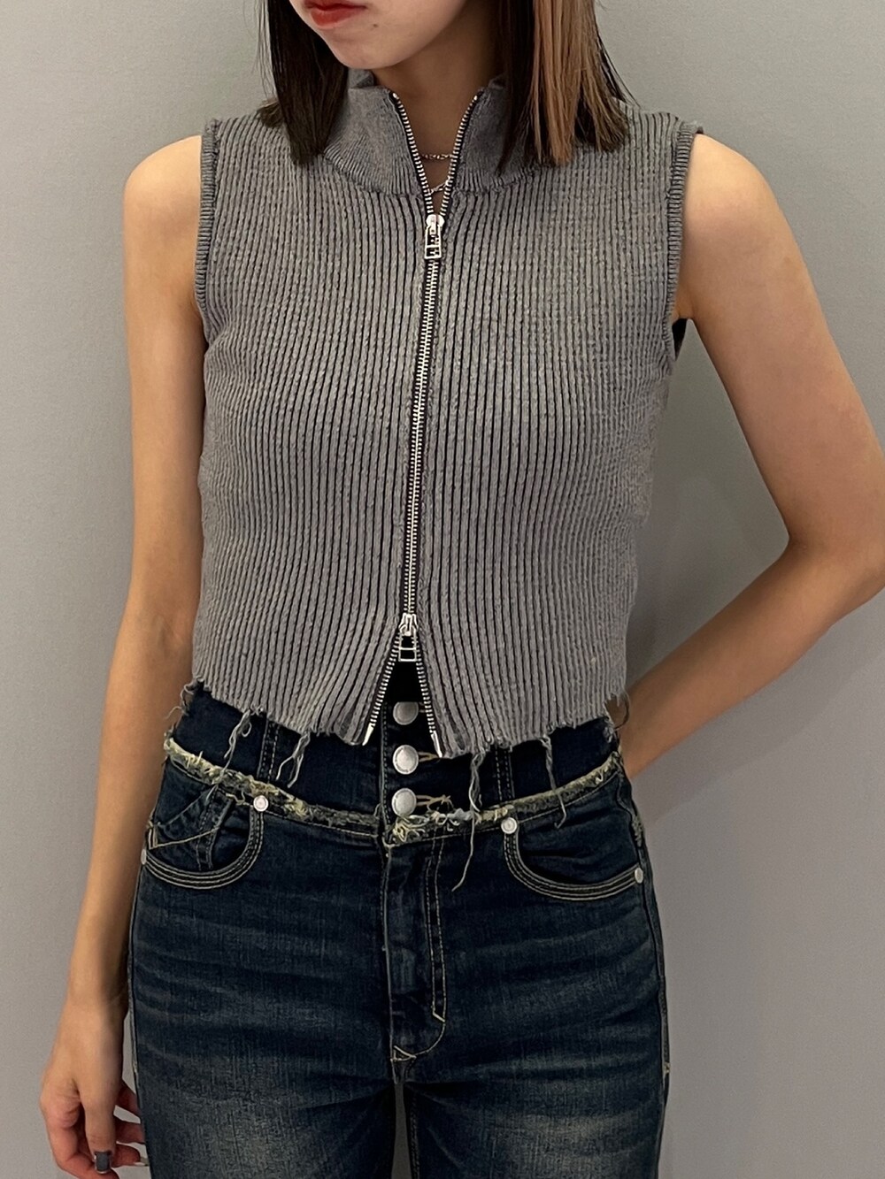 ブルー系のデニムパンツ、ブラック系のブーツ、グレー系のニット/セーターを着用したレディースの秋コーディネートの7枚目の写真