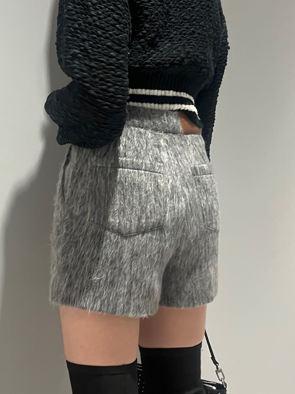 ホワイト系のブルゾン、ブラック系のカーディガン/ボレロ、グレー系のその他パンツを着用したレディースの冬コーディネートの9枚目の写真