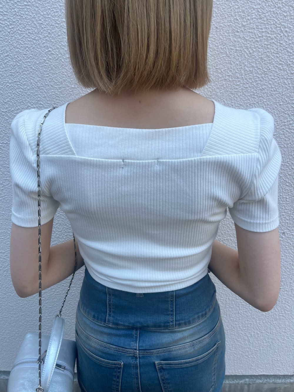 ホワイト系のTシャツ/カットソー、ブルー系のデニムパンツ、シルバー系のハンドバッグを着用したレディースの夏コーディネートの5枚目の写真