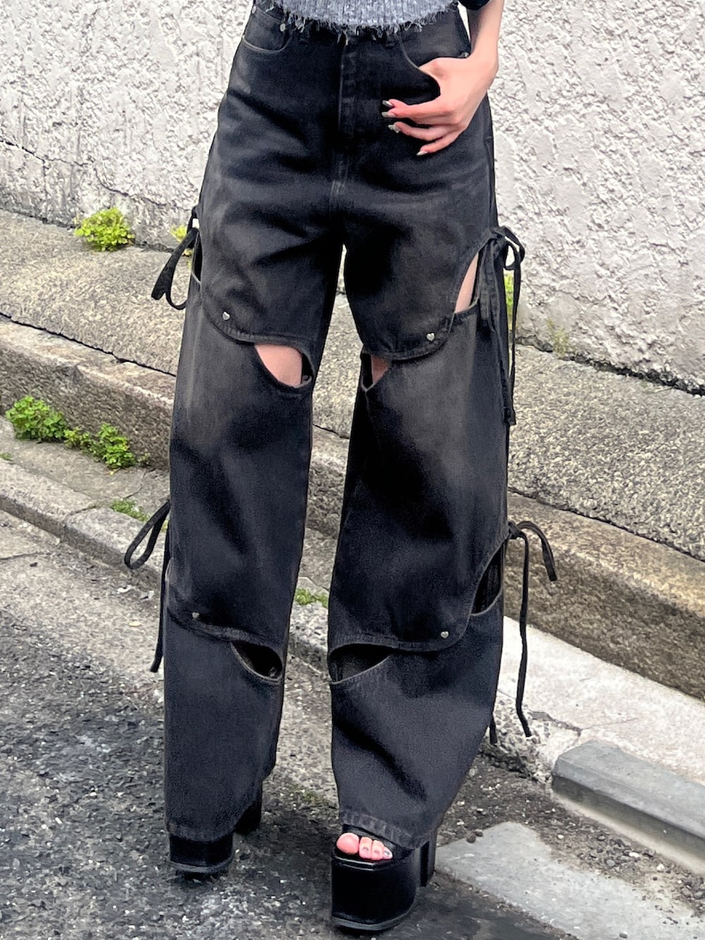 ブラック系のデニムパンツ、ブラック系のサンダル、グレー系のニット/セーターを着用したレディースの春コーディネートの5枚目の写真