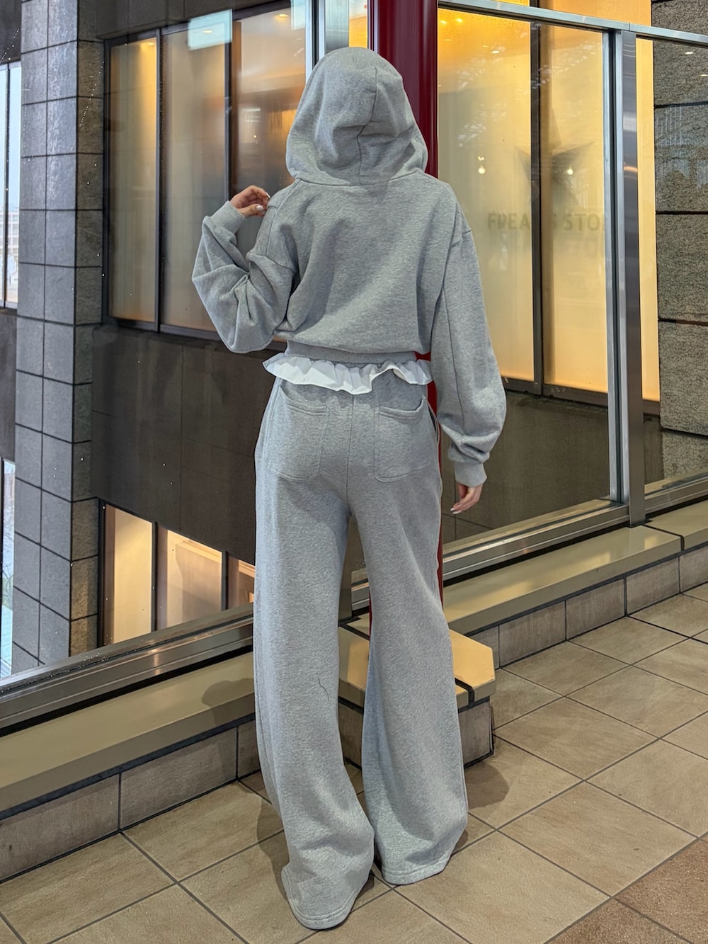 グレー系のスウェットパンツ、グレー系のパーカー、ブラック系のブーツを着用したレディースの冬コーディネートの3枚目の写真