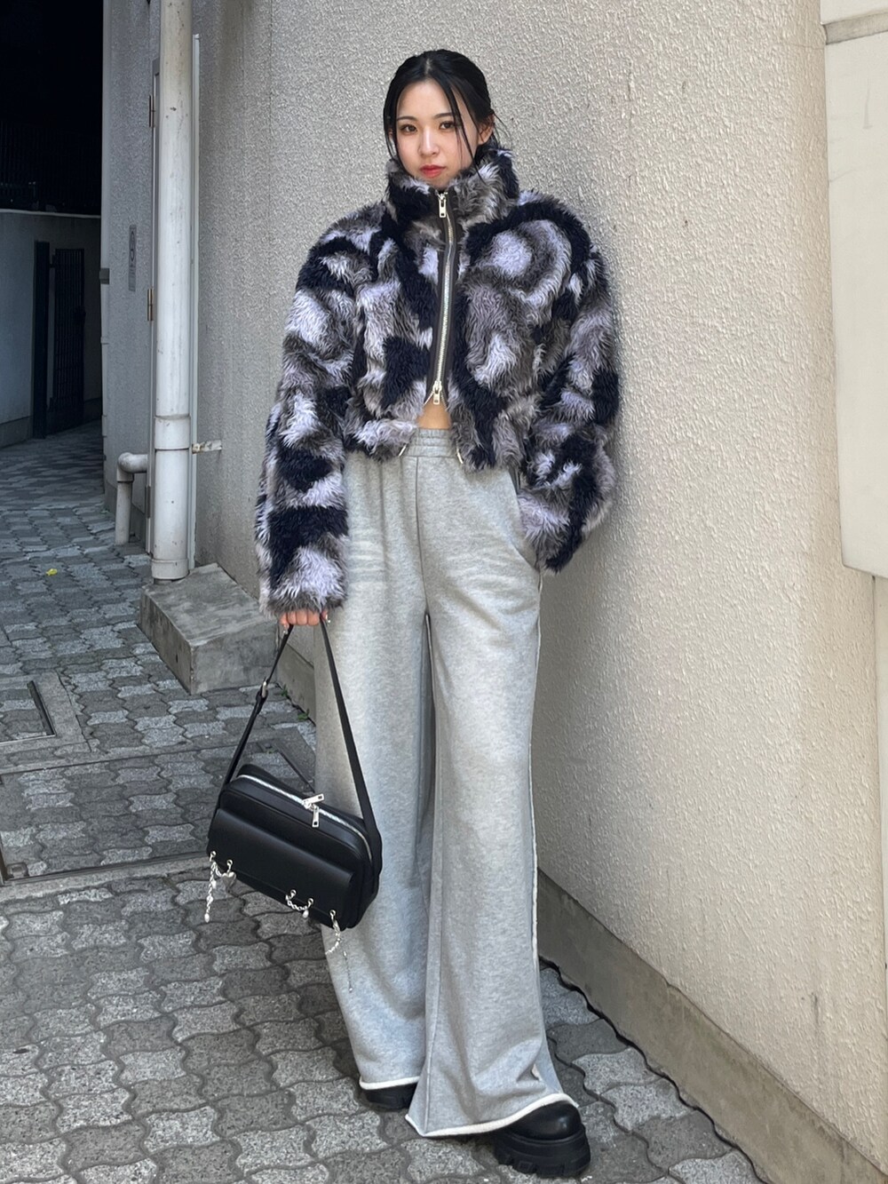 ブルー系のブルゾン、グレー系のスウェットパンツ、ブラック系のハンドバッグを着用したレディースの秋コーディネートの4枚目の写真