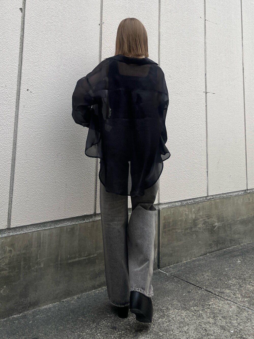 グレー系のデニムパンツ、ブラック系のサンダル、ブラック系のタンクトップを着用したレディースの春コーディネートの3枚目の写真