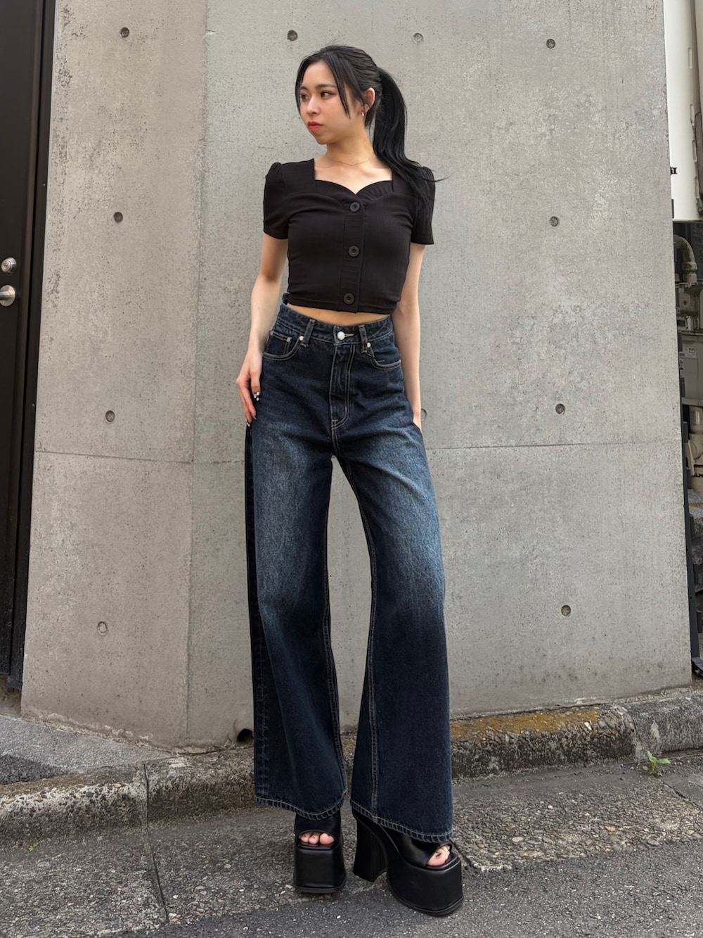 ブルー系のデニムパンツ、ブラック系のサンダルを着用したレディースの春コーディネートの2枚目の写真