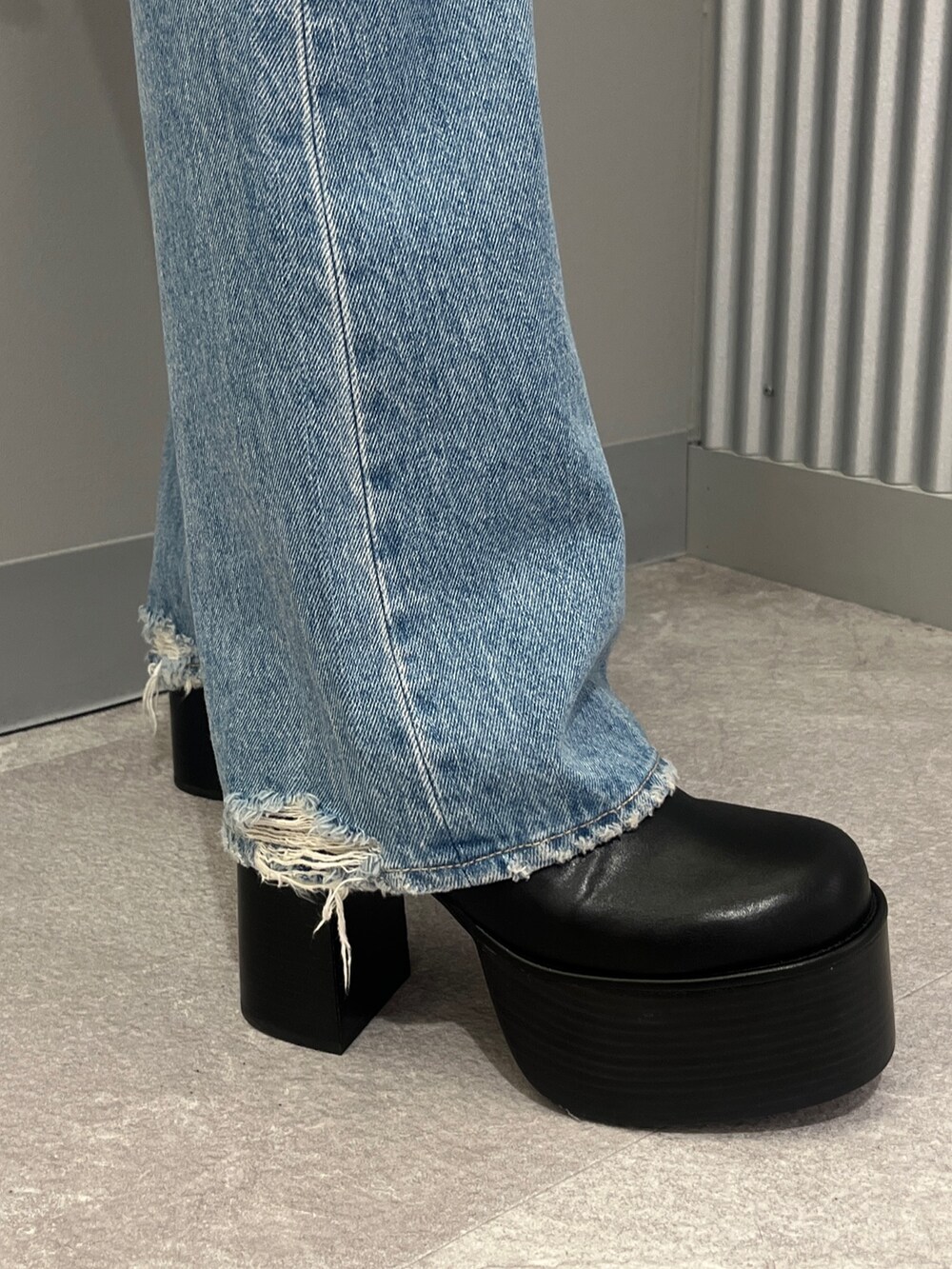 ブルー系のデニムパンツ、ブラック系のブーツ、グリーン系のキャミソールを着用したレディースの冬コーディネートの6枚目の写真