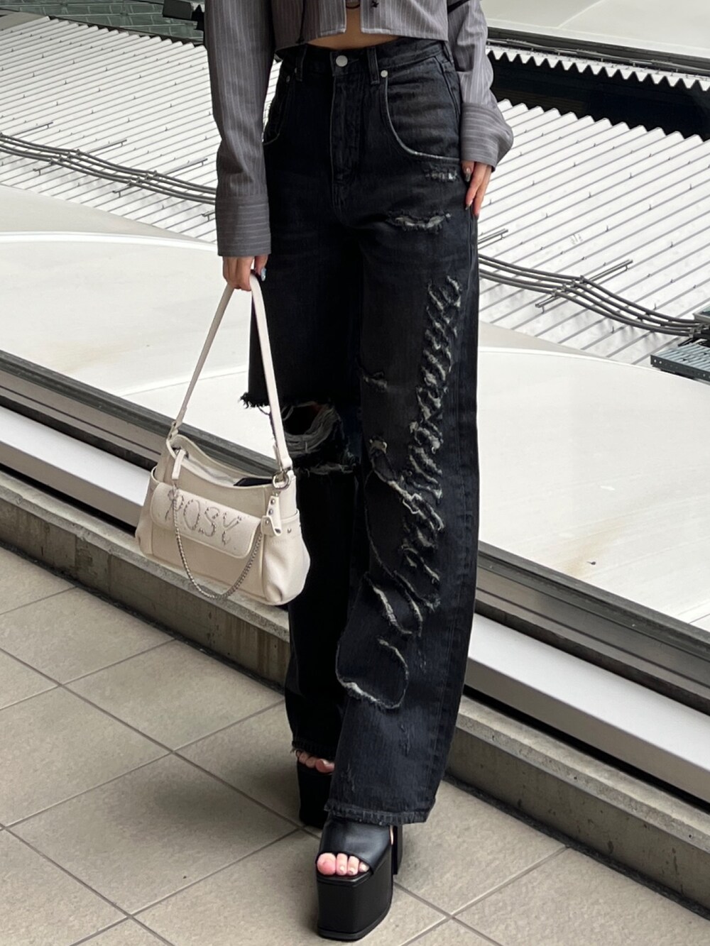 グレー系のシャツ/ブラウス、ブラック系のデニムパンツ、ブラック系のサンダルを着用したレディースの春コーディネートの5枚目の写真