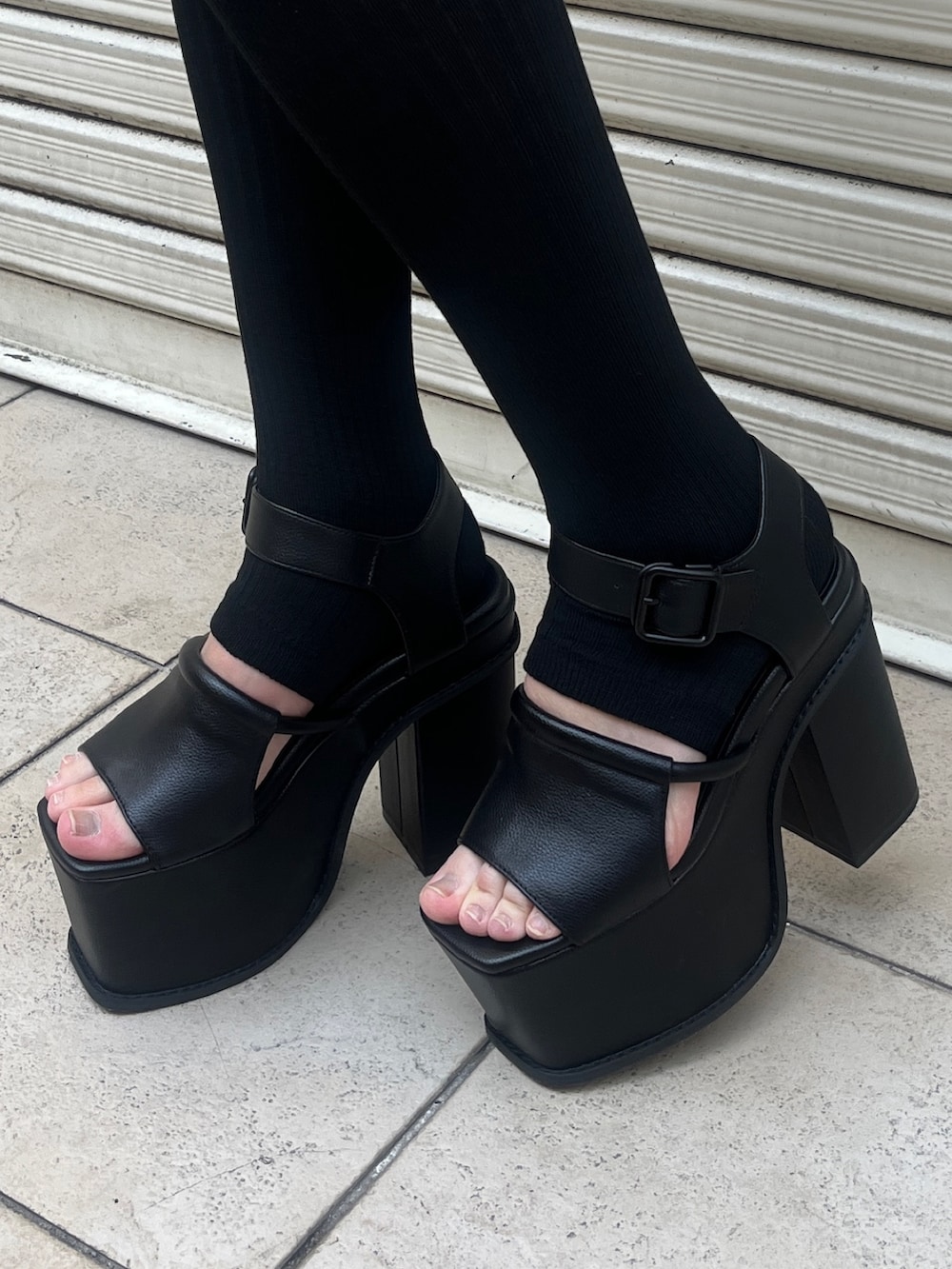 グレー系のタンクトップ、ブルー系のデニムパンツ、ブラック系のハンドバッグを着用したレディースの春コーディネートの6枚目の写真