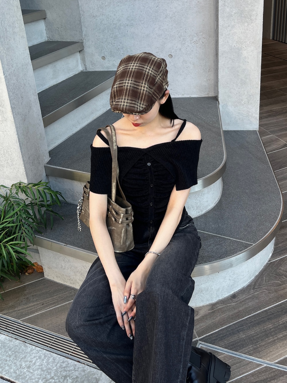 ブラック系のニット/セーター、ブラック系のデニムパンツ、ブラウン系のショルダーバッグを着用したレディースの夏コーディネートの3枚目の写真