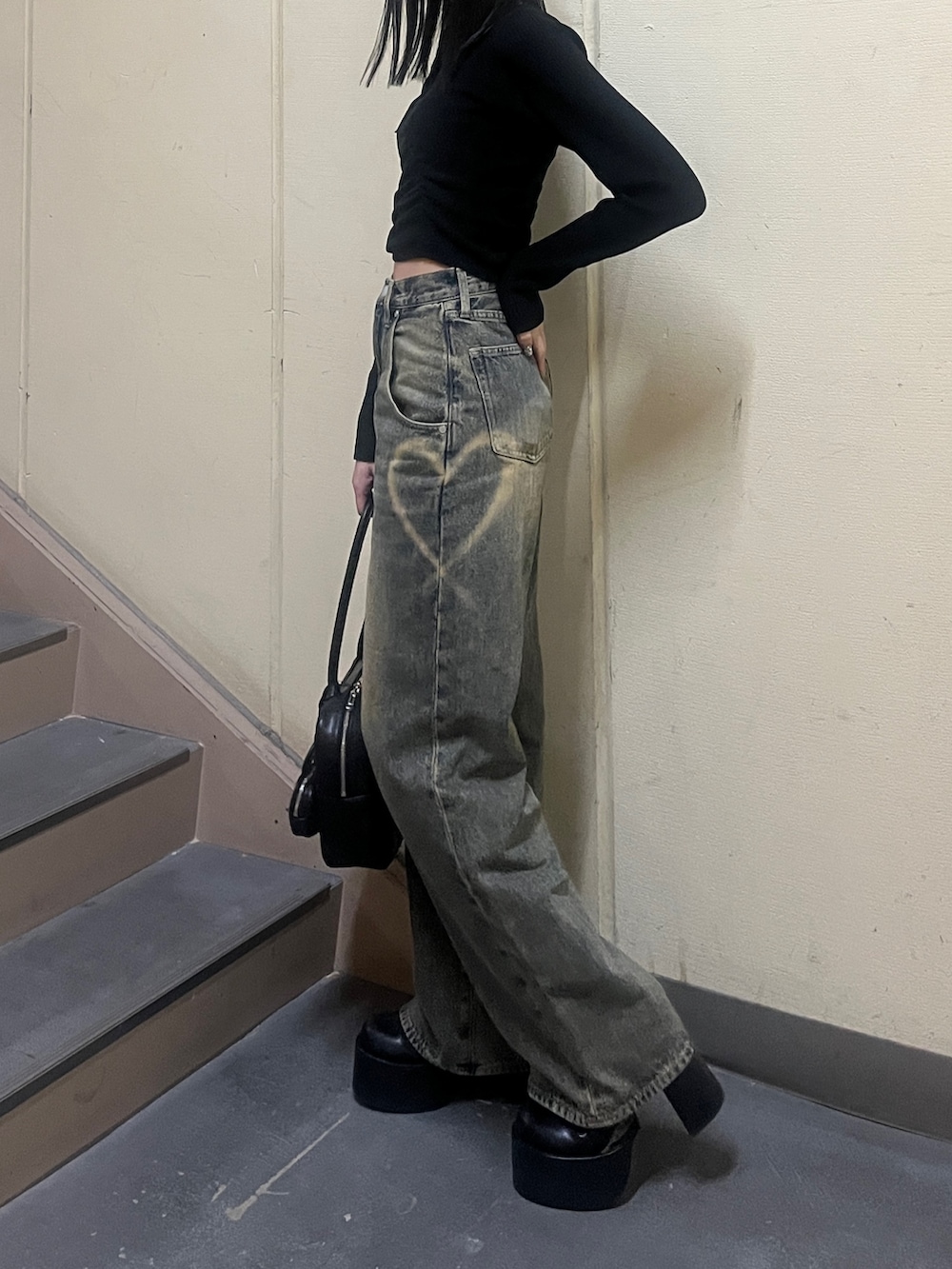 ブラック系のニット/セーター、ブラウン系のブルゾン、ブルー系のデニムパンツを着用したレディースの冬コーディネートの4枚目の写真