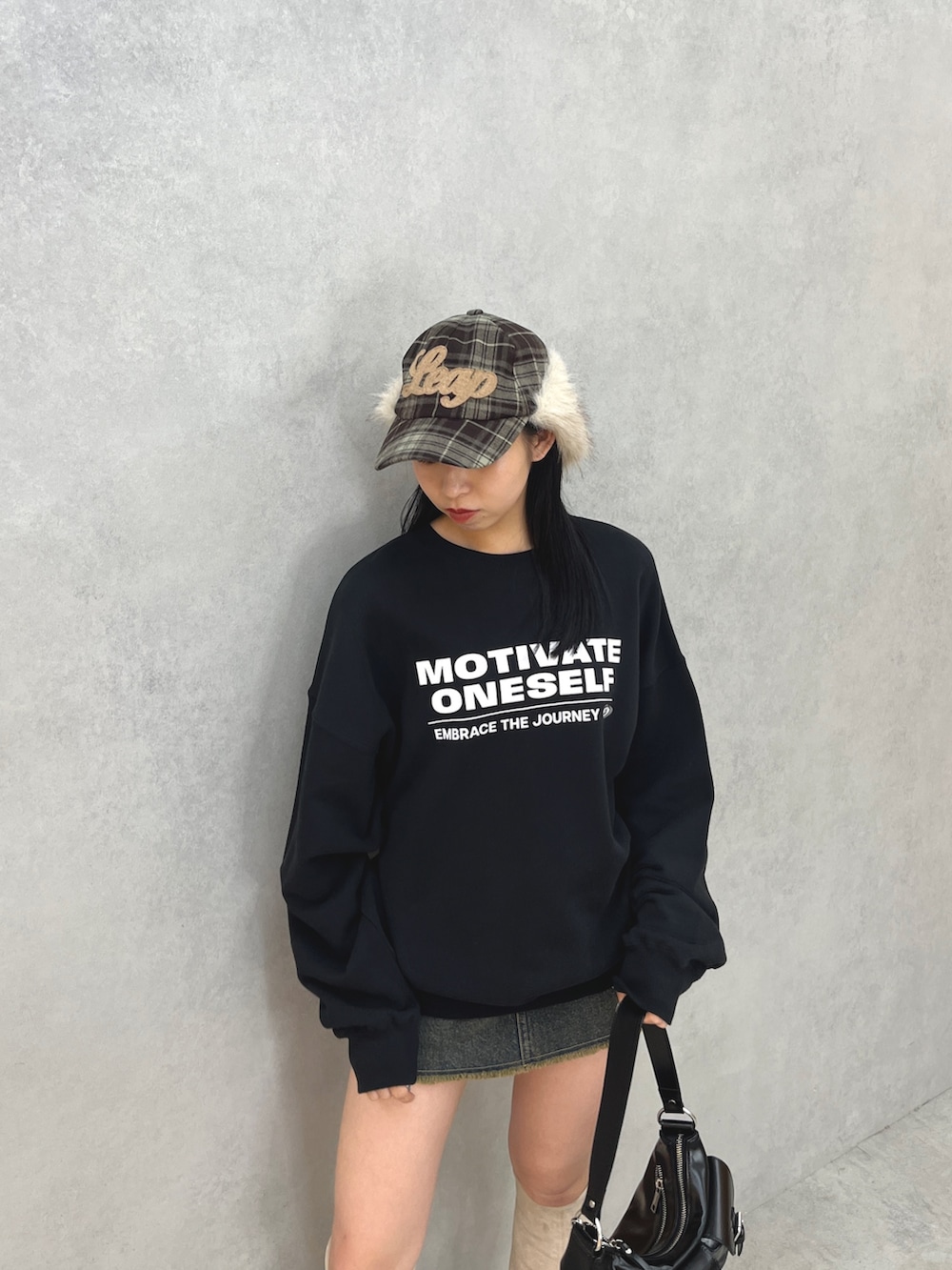 ブラック系のスウェット、ブルー系のスカート、ブラック系のハンドバッグを着用したレディースの秋コーディネートの4枚目の写真