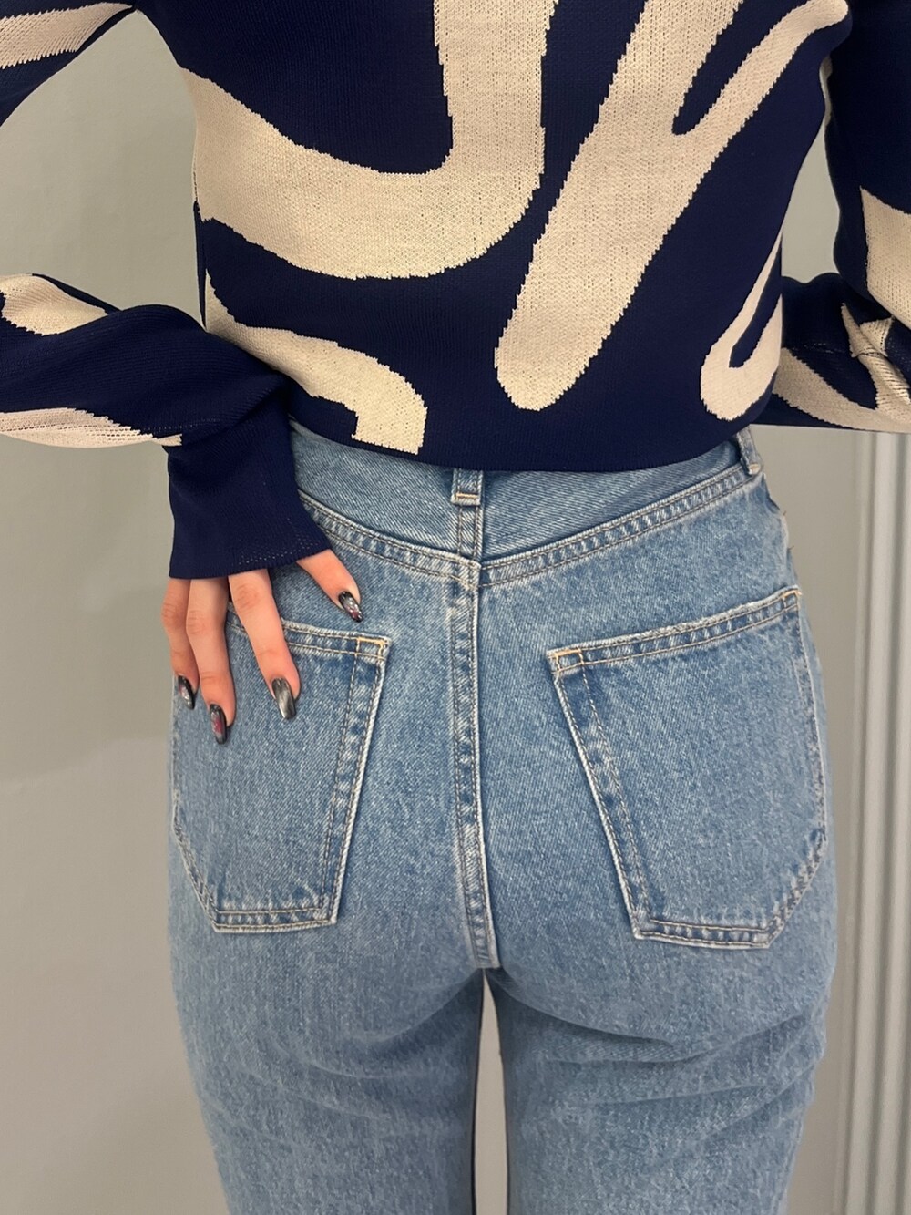 ブルー系のデニムパンツ、ブラック系のブーツ、グリーン系のキャミソールを着用したレディースの冬コーディネートの5枚目の写真