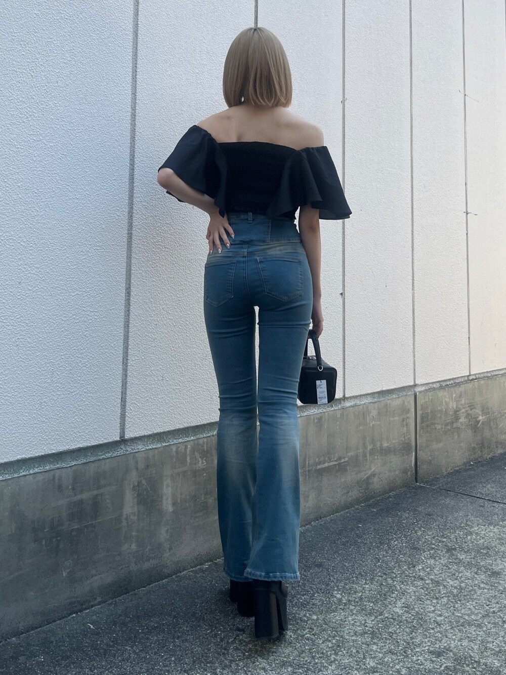 ブラック系のTシャツ/カットソー、ブルー系のデニムパンツ、ブラック系のハンドバッグを着用したレディースの夏コーディネートの3枚目の写真
