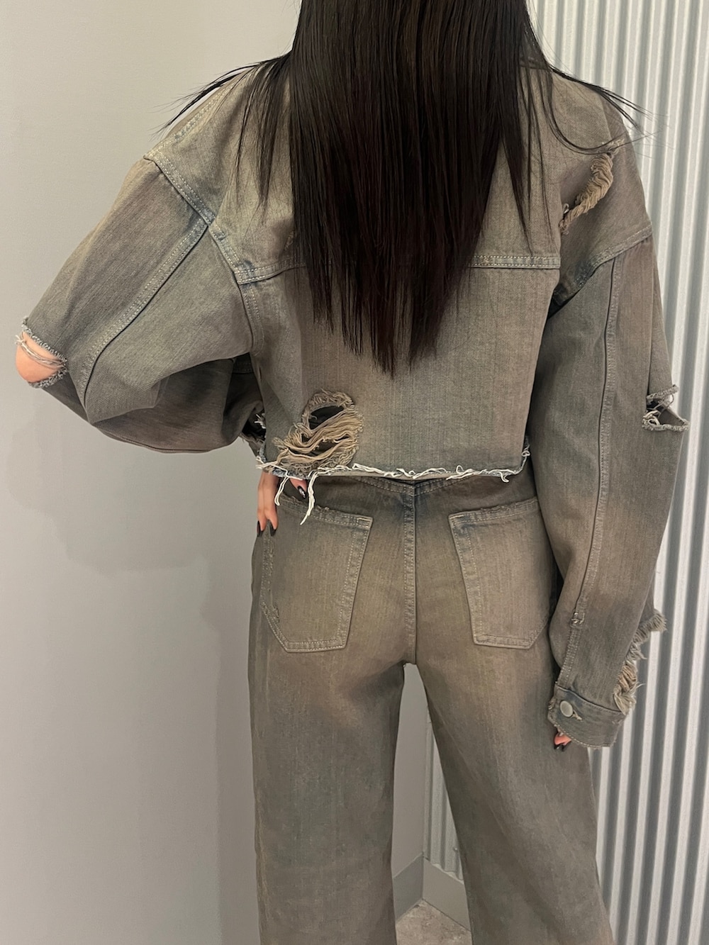 グレー系のデニムパンツ、ブラック系のサンダル、グレー系のデニムジャケットを着用したレディースの冬コーディネートの6枚目の写真