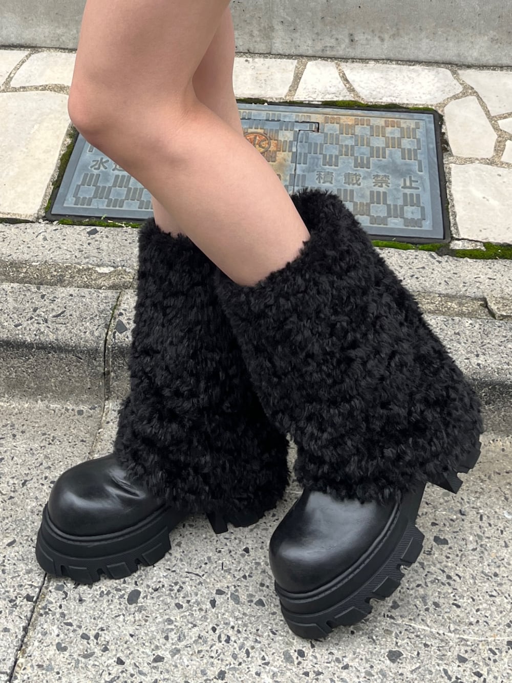 ブラック系のブーツ、ホワイト系のブルゾン、ブラック系のスカートを着用したレディースの冬コーディネートの4枚目の写真