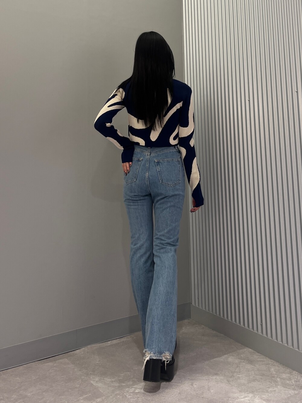 ブルー系のデニムパンツ、ブラック系のブーツ、グリーン系のキャミソールを着用したレディースの冬コーディネートの3枚目の写真