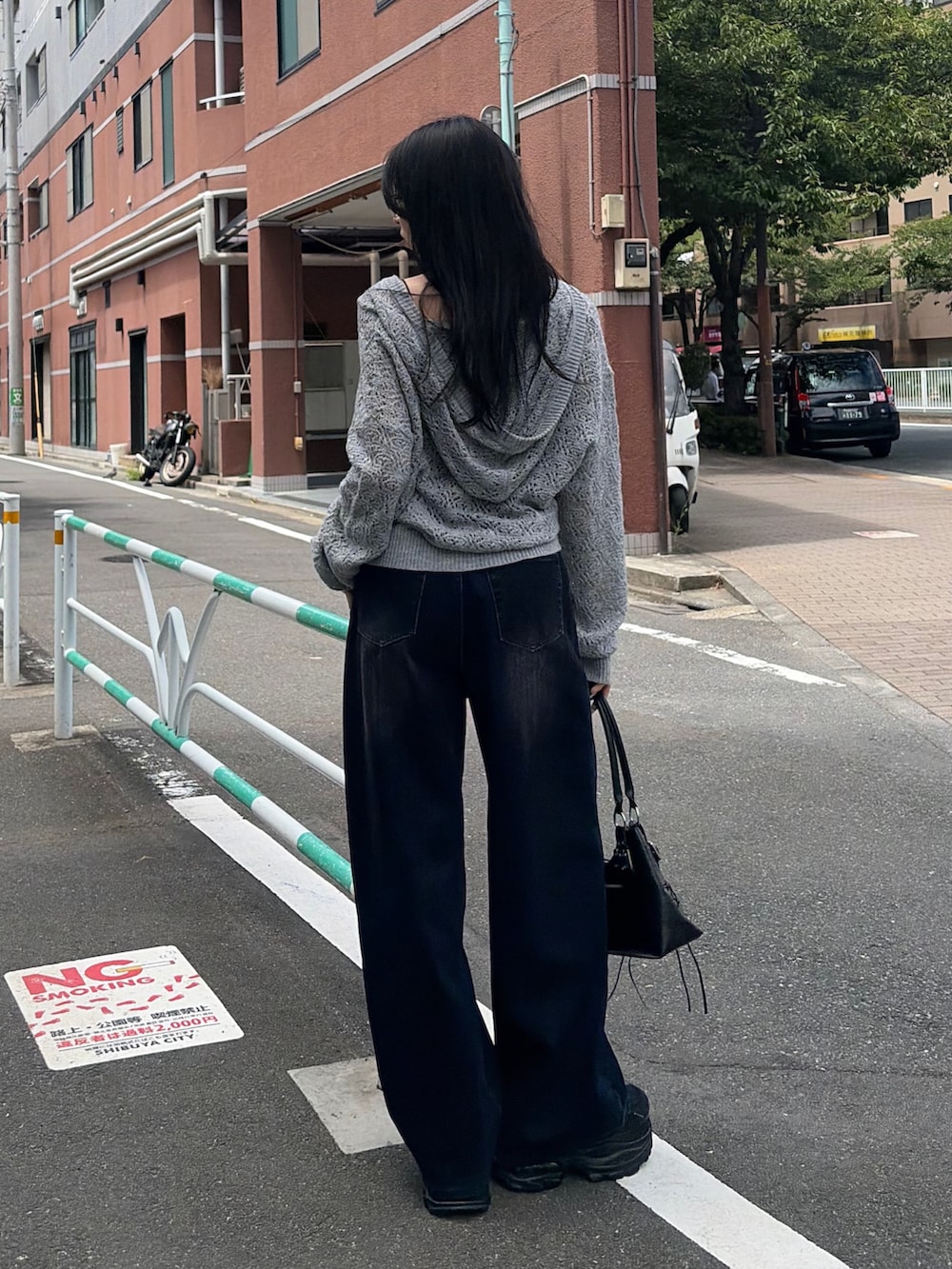 グレー系のニット/セーター、ブラック系のショルダーバッグ、ブルー系のデニムパンツを着用したレディースの夏コーディネートの3枚目の写真