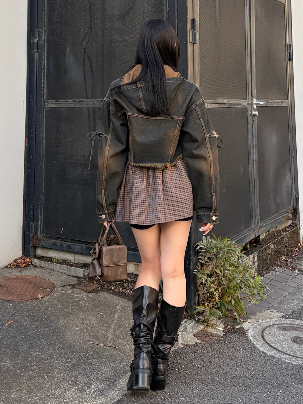 ブルー系のデニムジャケット、ブルー系のスカート、ブラック系のブーツを着用したレディースの冬コーディネートの3枚目の写真