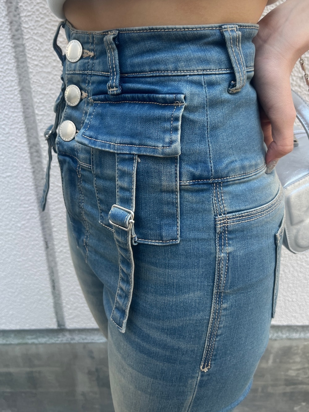 ホワイト系のTシャツ/カットソー、ブルー系のデニムパンツ、シルバー系のハンドバッグを着用したレディースの夏コーディネートの7枚目の写真