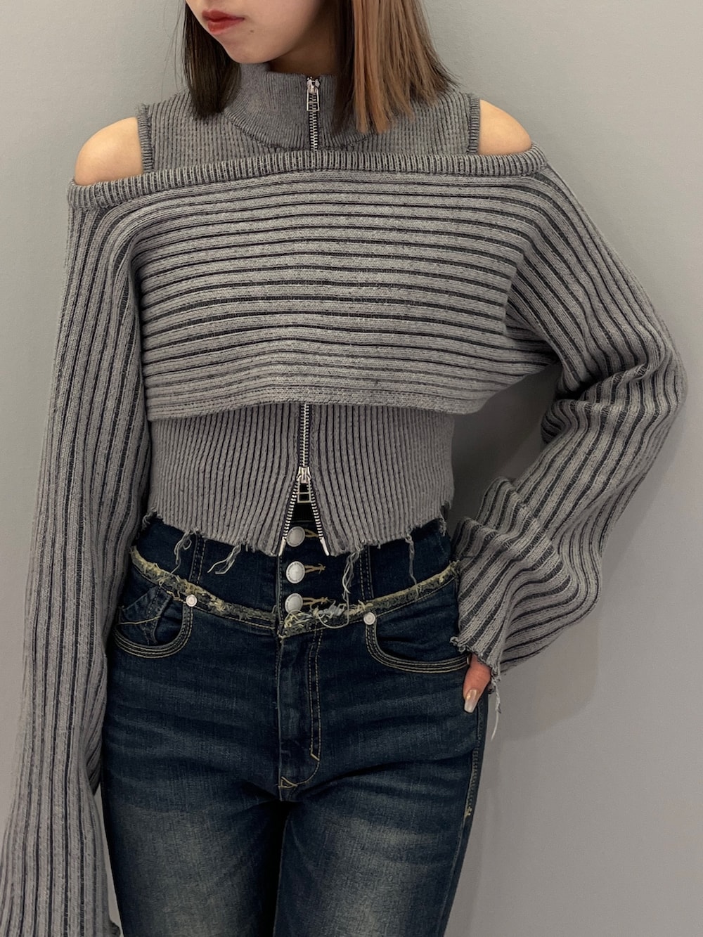 ブルー系のデニムパンツ、ブラック系のブーツ、グレー系のニット/セーターを着用したレディースの秋コーディネートの5枚目の写真