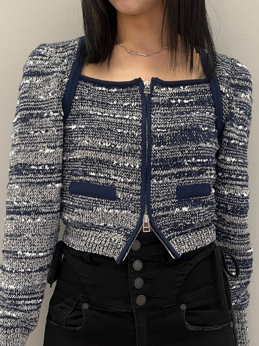 ブルー系のニット/セーター、ブラック系のデニムパンツ、ブラック系のショルダーバッグを着用したレディースの冬コーディネートの4枚目の写真