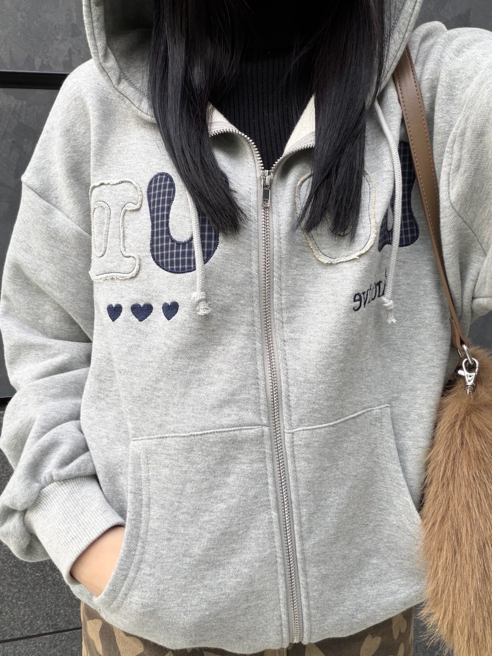 グレー系のパーカー、ベージュ系のスカート、ベージュ系のショルダーバッグを着用したレディースの冬コーディネートの4枚目の写真