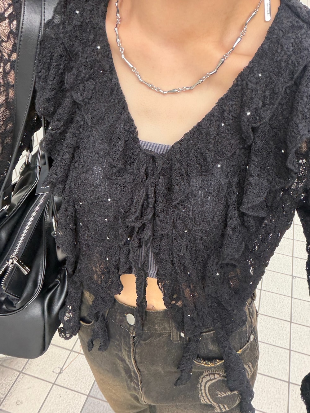 ブラック系のTシャツ/カットソー、ブラック系のキャミソール、ブラック系のデニムパンツを着用したレディースの春コーディネートの6枚目の写真