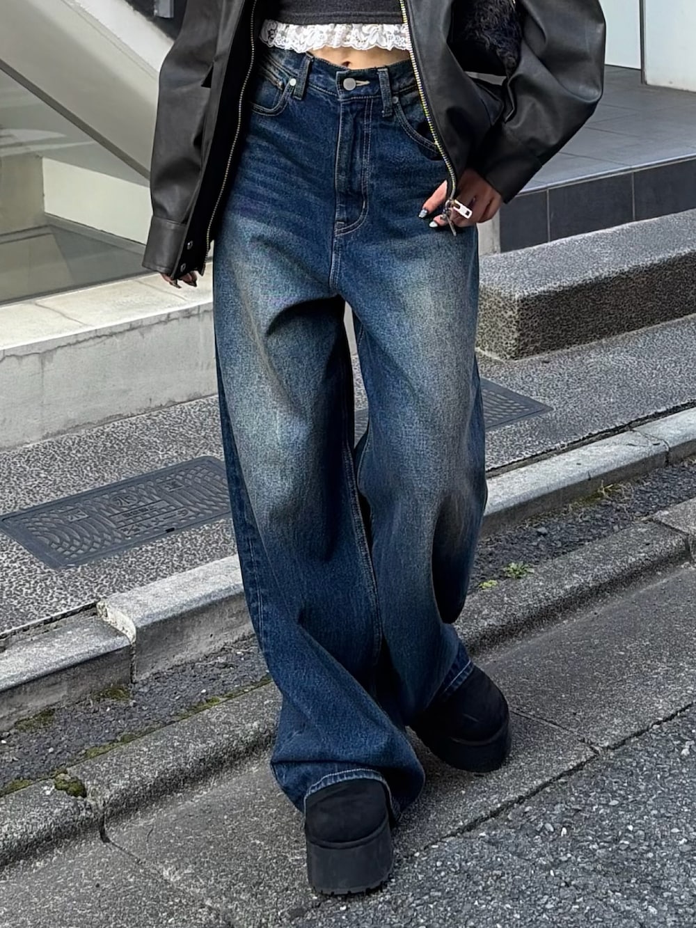 ブラック系のブルゾン、ブラック系のTシャツ/カットソー、ブルー系のデニムパンツを着用したレディースの秋コーディネートの5枚目の写真