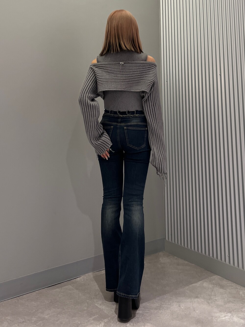 ブルー系のデニムパンツ、ブラック系のブーツ、グレー系のニット/セーターを着用したレディースの秋コーディネートの3枚目の写真