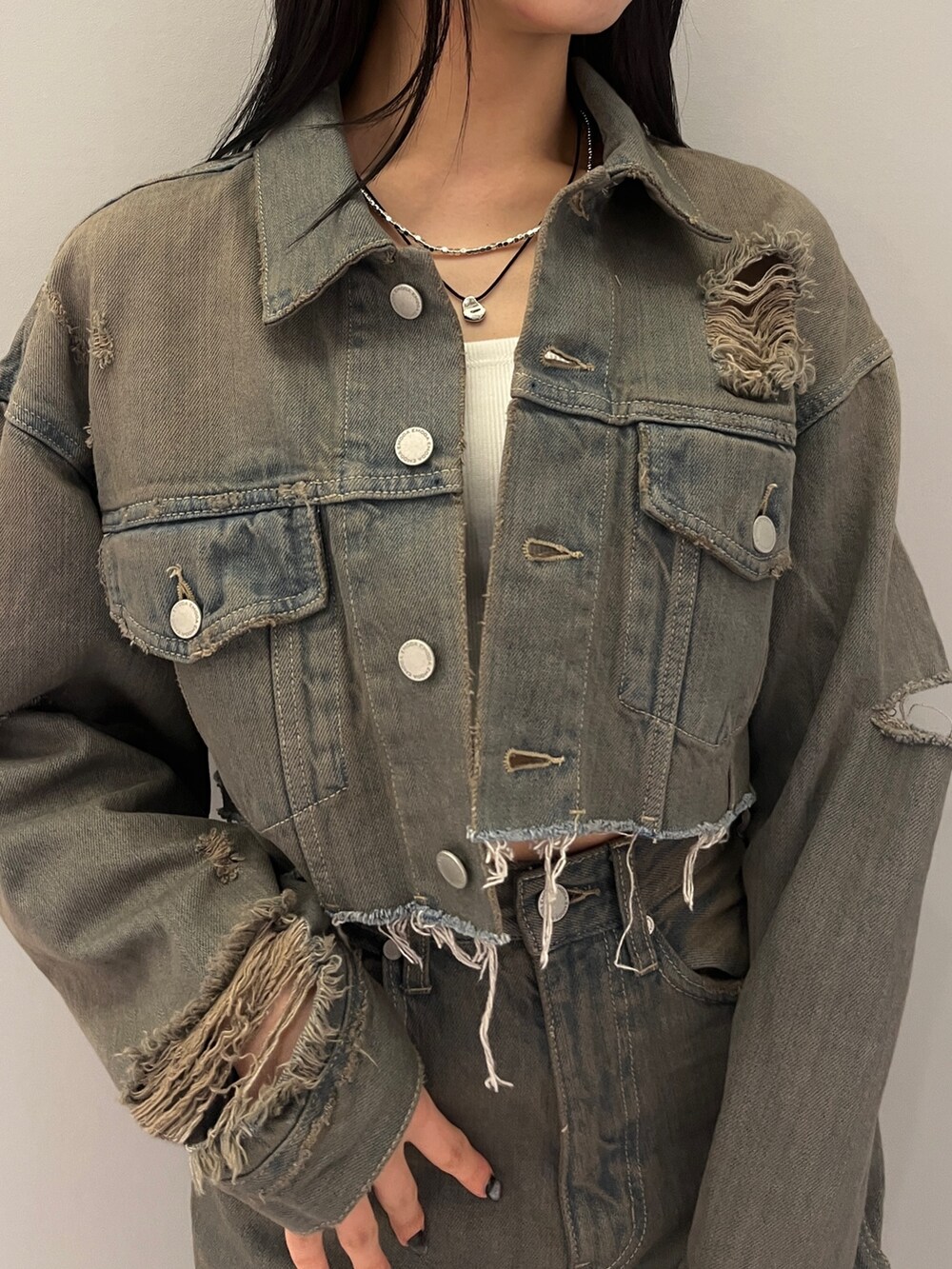 グレー系のデニムパンツ、ブラック系のサンダル、グレー系のデニムジャケットを着用したレディースの冬コーディネートの4枚目の写真