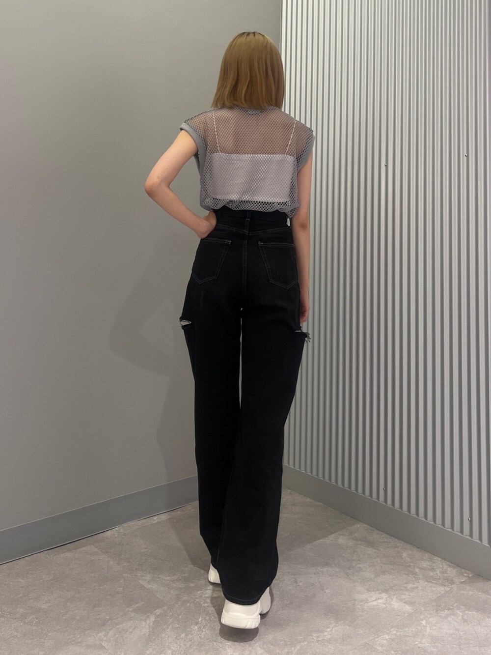 ブラック系のデニムパンツ、グレー系のTシャツ/カットソー、ホワイト系のサンダルを着用したレディースの夏コーディネートの3枚目の写真