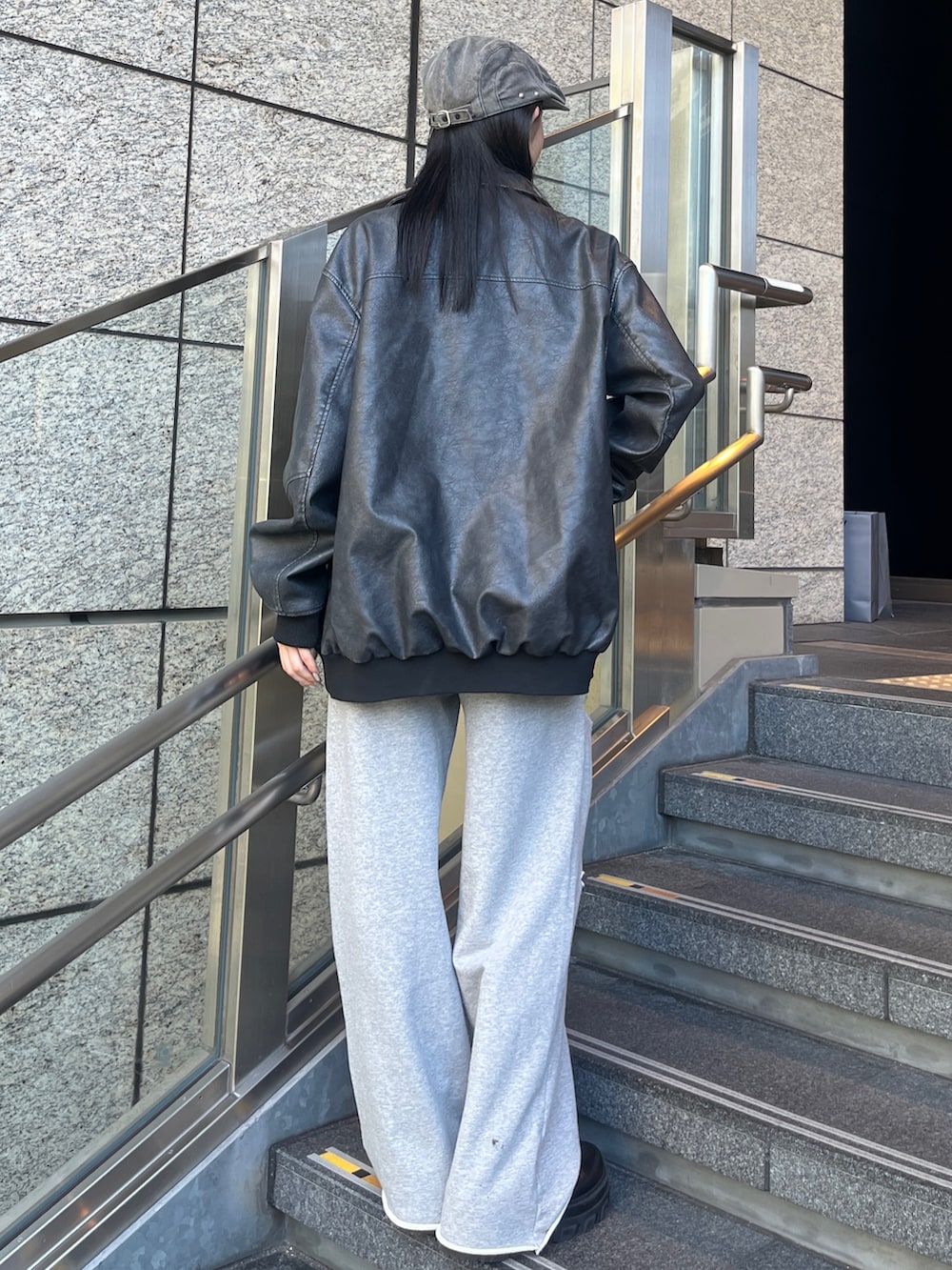 ブラック系のブーツ、グレー系のブルゾン、グレー系のスウェットパンツを着用したレディースの秋コーディネートの2枚目の写真