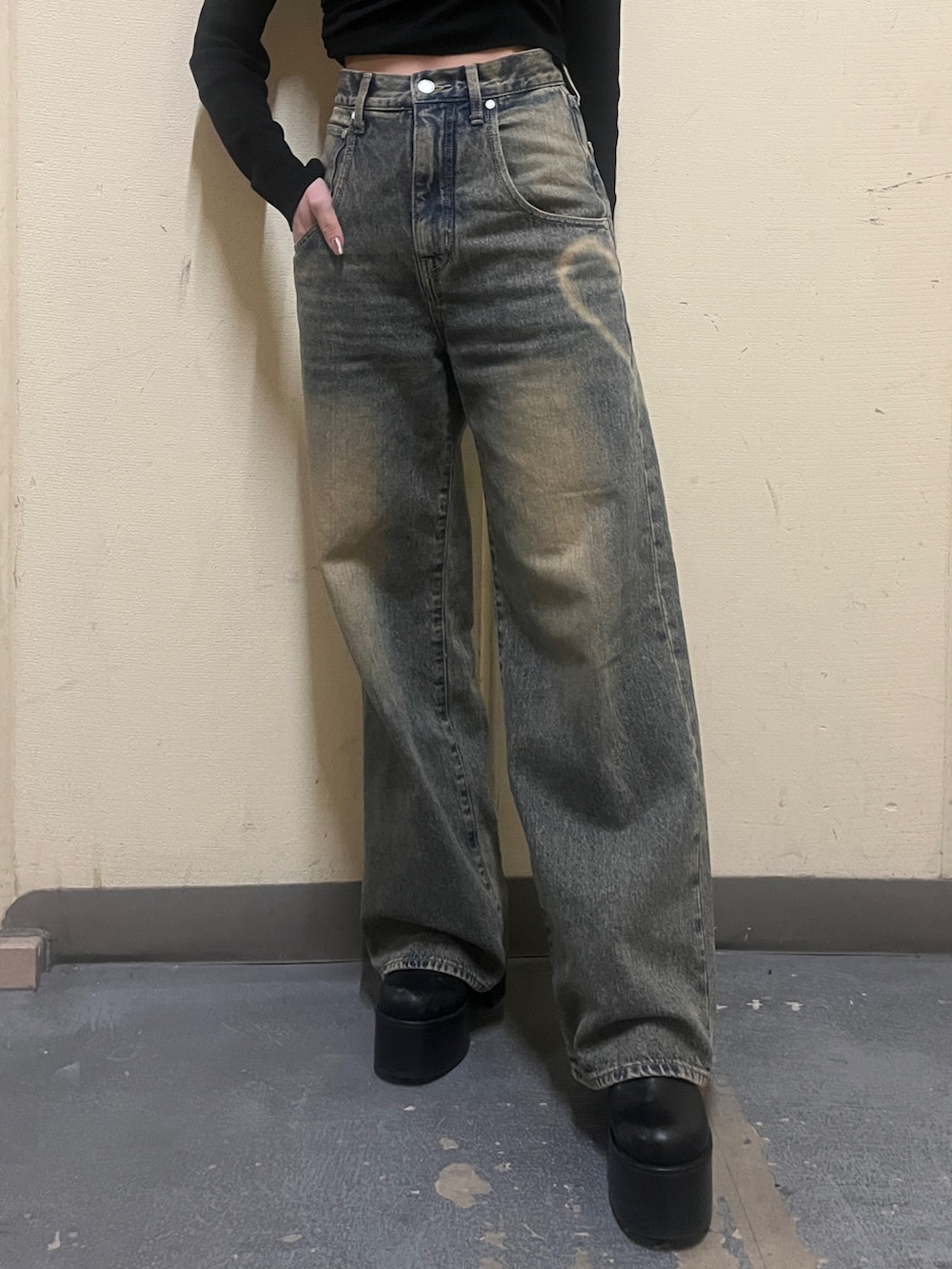 ブラック系のニット/セーター、ブラウン系のブルゾン、ブルー系のデニムパンツを着用したレディースの冬コーディネートの8枚目の写真