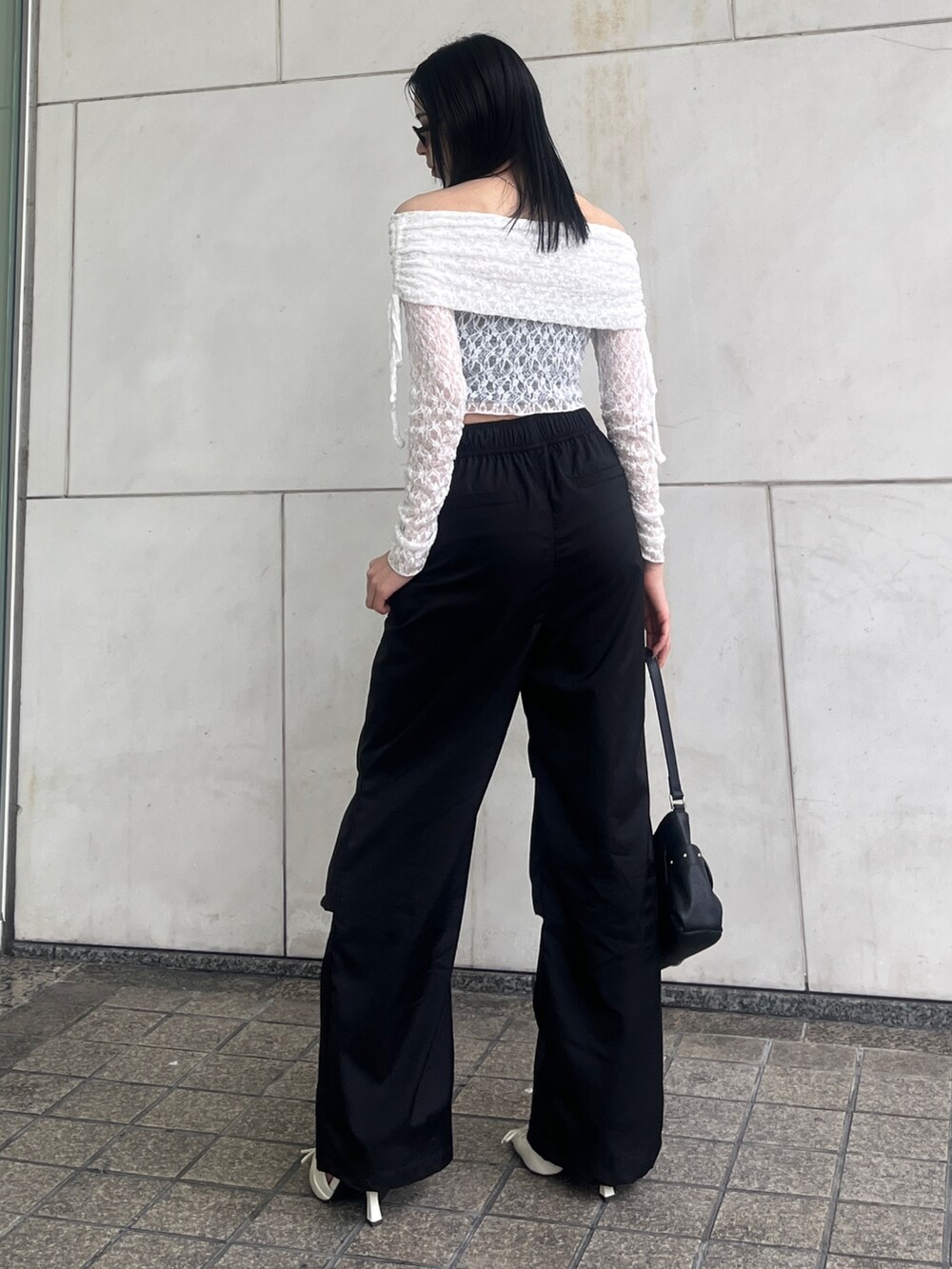 ブラック系のその他パンツ、ブラック系のハンドバッグ、ホワイト系のパンプスを着用したレディースの春コーディネートの3枚目の写真