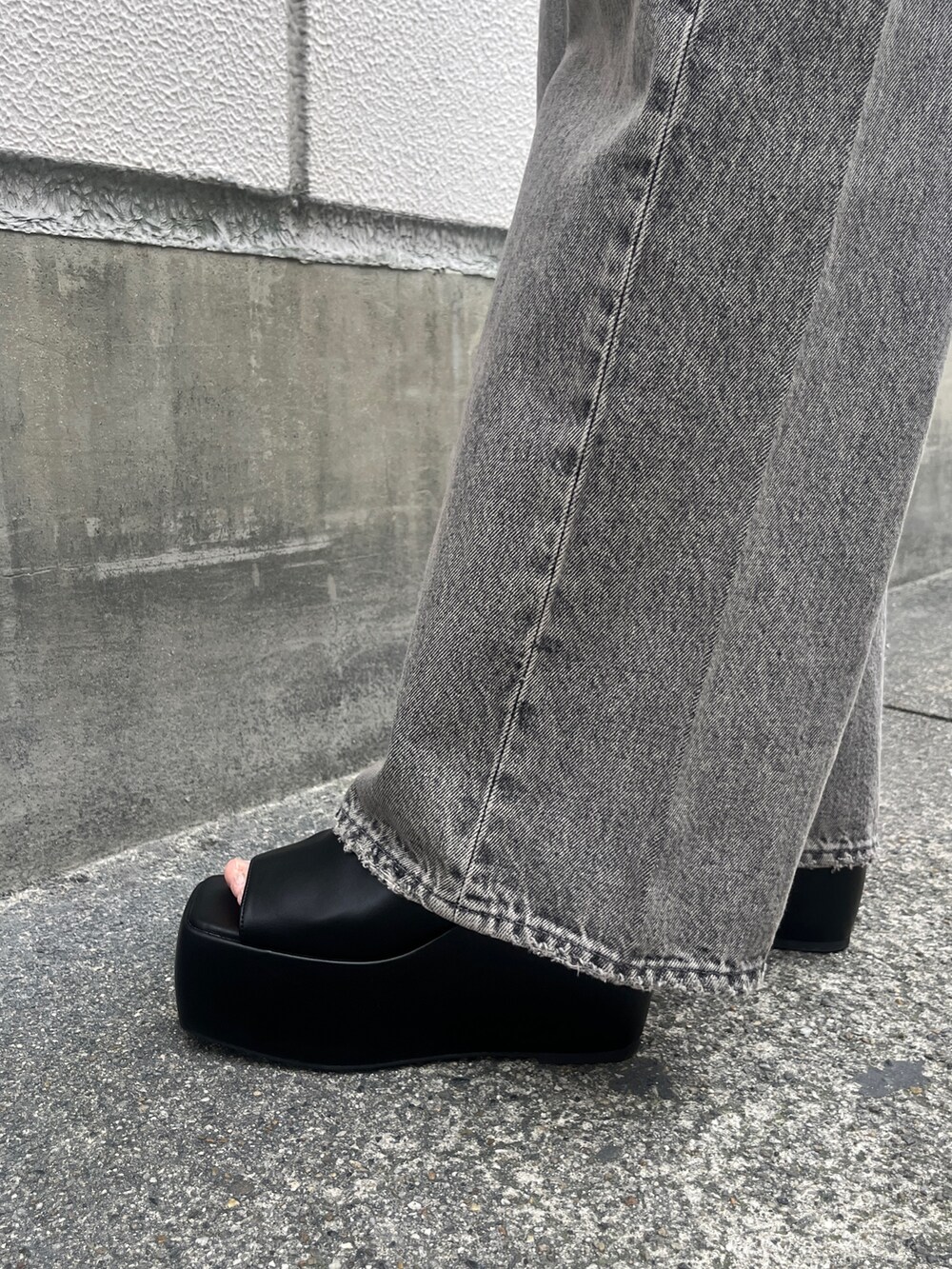 グレー系のデニムパンツ、ブラック系のサンダル、ブラック系のタンクトップを着用したレディースの春コーディネートの7枚目の写真