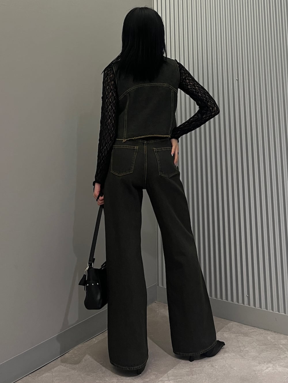 ブルー系のデニムパンツ、ブルー系のベスト、ブラック系のTシャツ/カットソーを着用したレディースの春コーディネートの3枚目の写真
