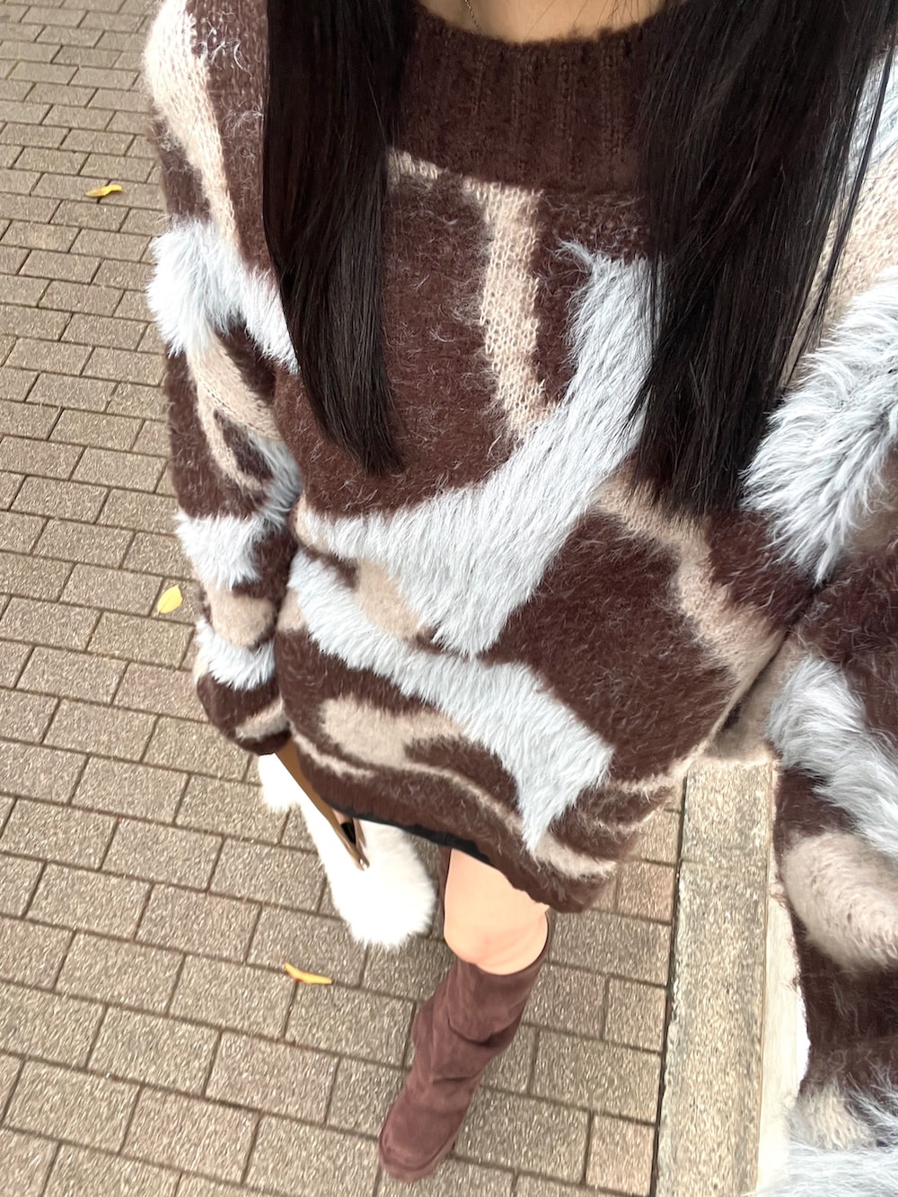 ブラウン系のニット/セーター、ブラウン系のブーツ、ホワイト系のショルダーバッグを着用したレディースの秋コーディネートの4枚目の写真