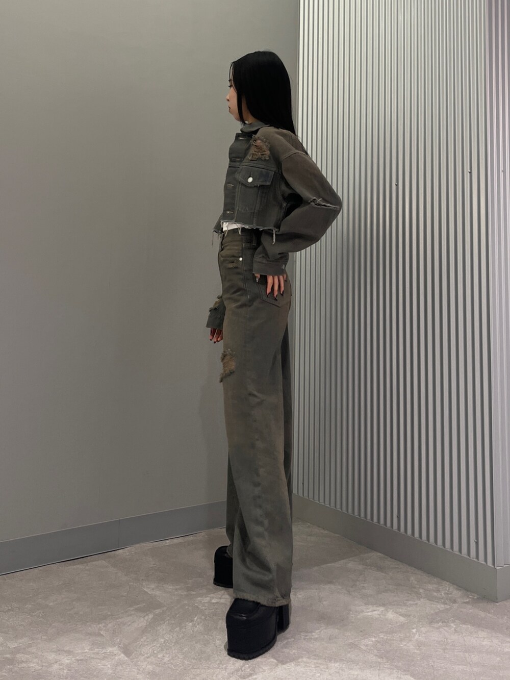 グレー系のデニムパンツ、ブラック系のサンダル、グレー系のデニムジャケットを着用したレディースの冬コーディネートの2枚目の写真
