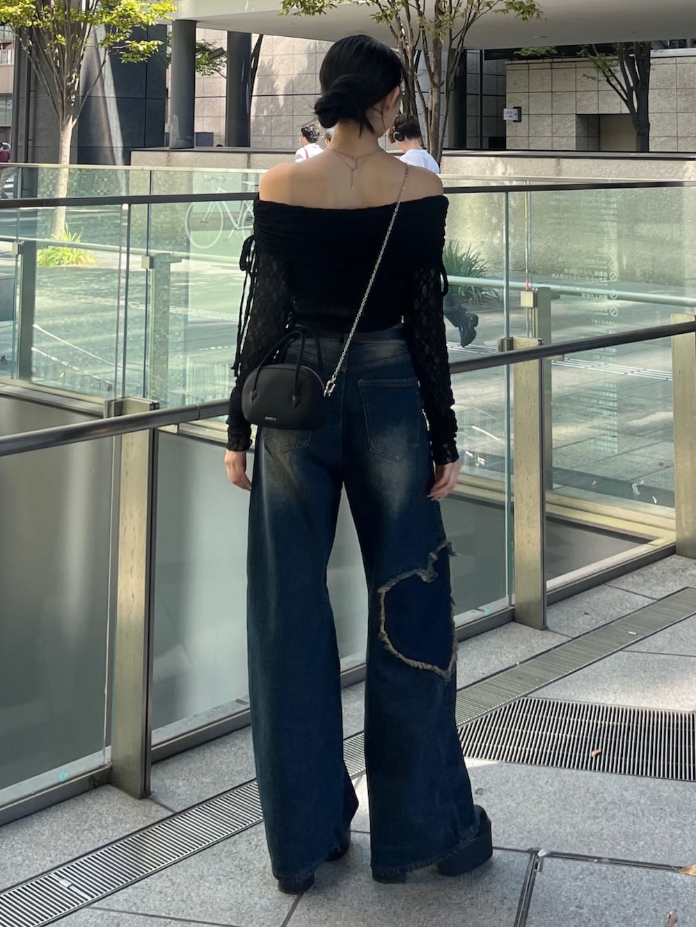 ブラック系のTシャツ/カットソー、ブルー系のデニムパンツ、ブラック系のブーツを着用したレディースの秋コーディネートの2枚目の写真