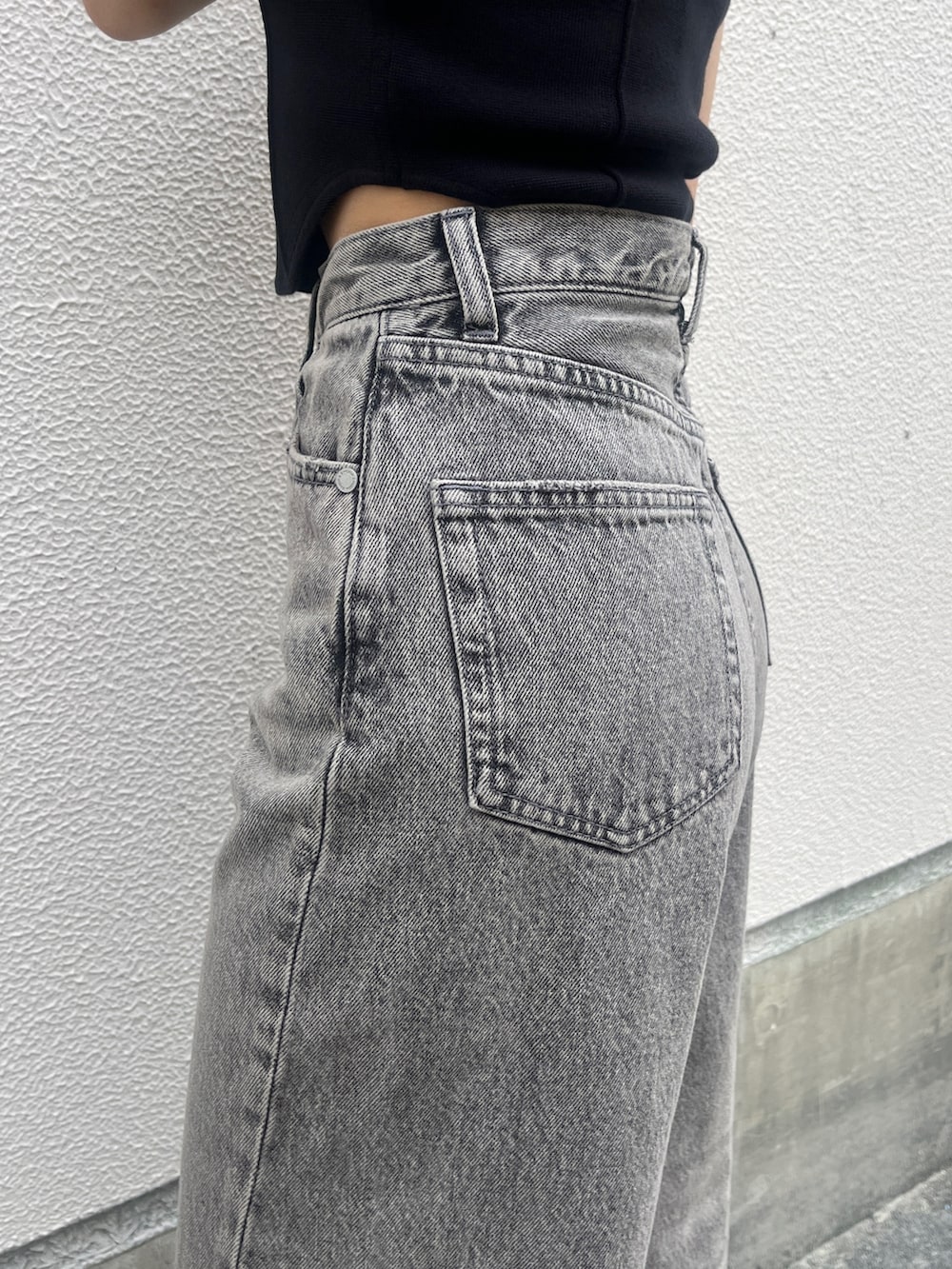 グレー系のデニムパンツ、ブラック系のサンダル、ブラック系のタンクトップを着用したレディースの春コーディネートの5枚目の写真