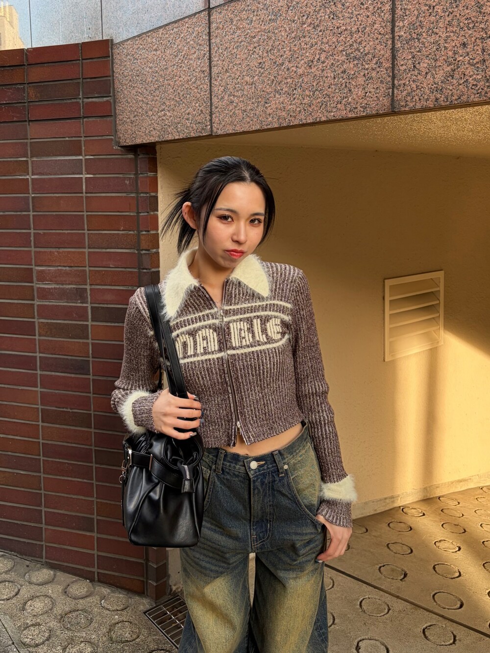 ブラウン系のニット/セーター、ブルー系のデニムパンツ、ブラック系のブーツを着用したレディースの冬コーディネートの4枚目の写真