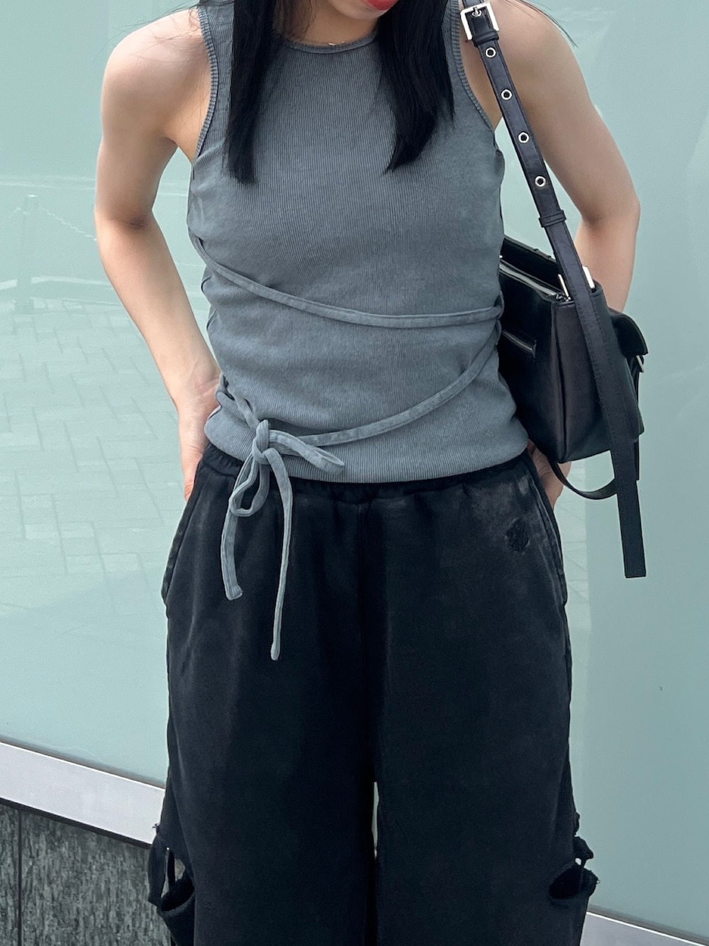 グレー系のTシャツ/カットソー、ブラック系のスウェットパンツ、ブラック系のハンドバッグを着用したレディースの夏コーディネートの3枚目の写真