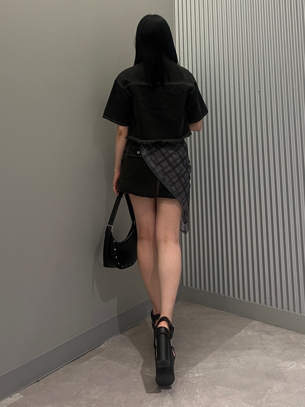 ブラック系のシャツ/ブラウス、ブラック系のスカート、ブラック系のハンドバッグを着用したレディースの春コーディネートの3枚目の写真