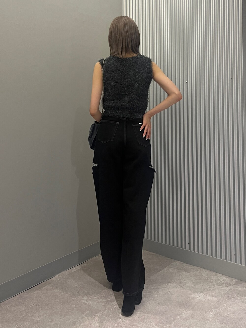 ブラック系のデニムパンツ、グレー系のハンドバッグ、ブラック系のサンダルを着用したレディースの夏コーディネートの3枚目の写真