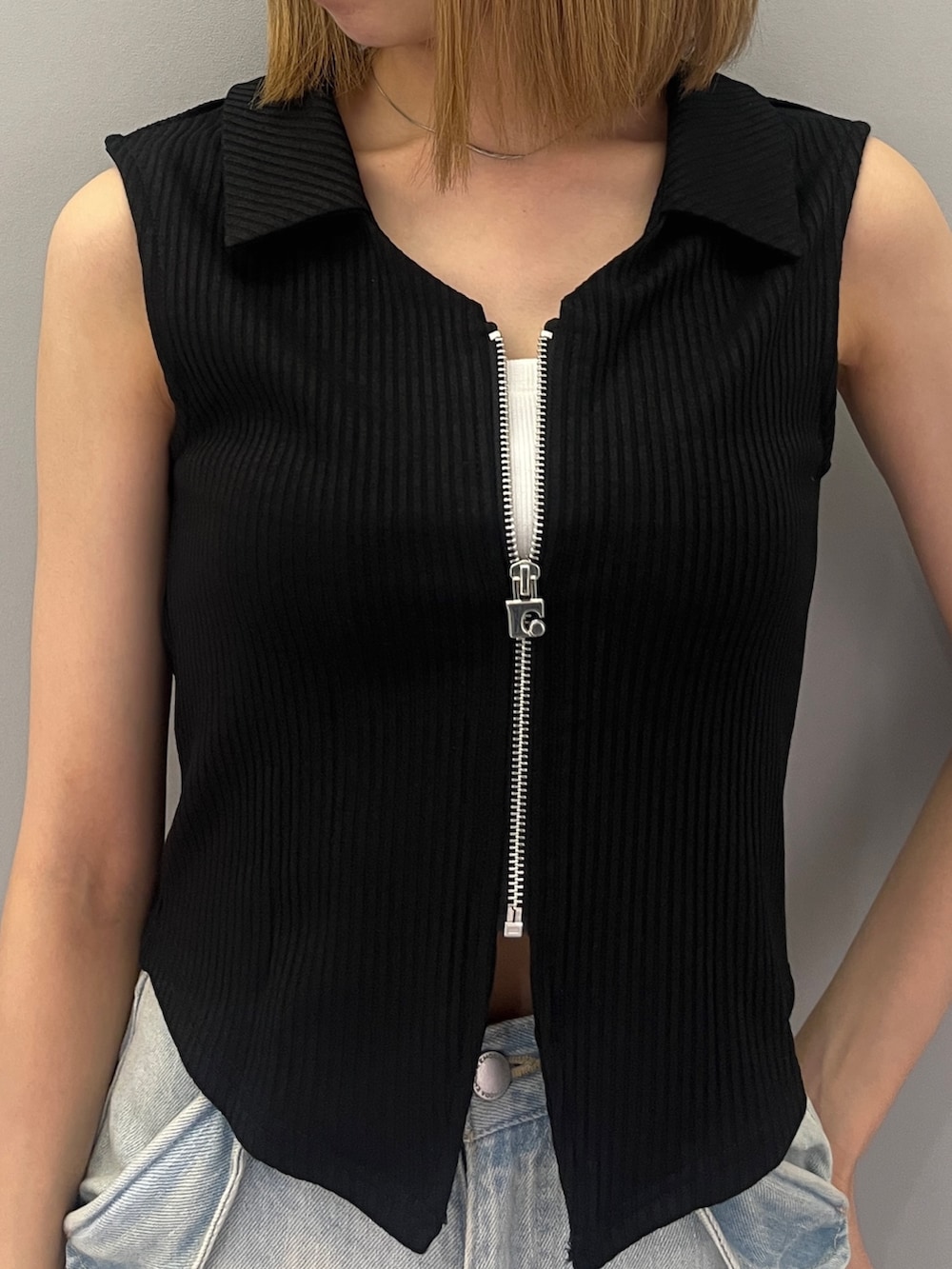 ブラック系のタンクトップ、ブラック系のショルダーバッグ、ブルー系のデニムパンツを着用したレディースの夏コーディネートの4枚目の写真