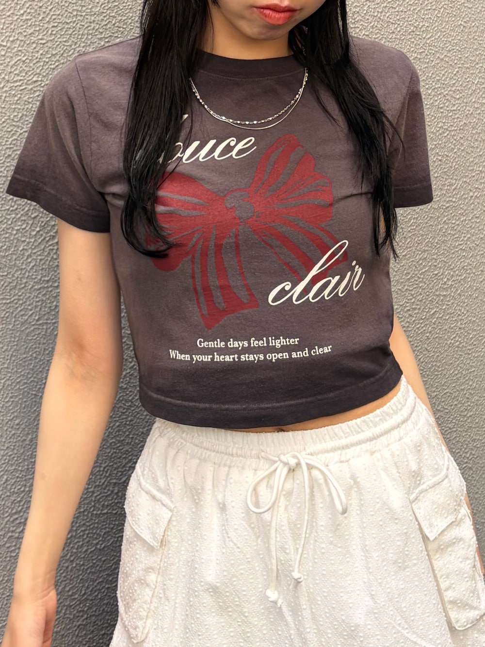 ブラック系のTシャツ/カットソー、ホワイト系のスカート、ブラック系のサンダルを着用したレディースの夏コーディネートの4枚目の写真