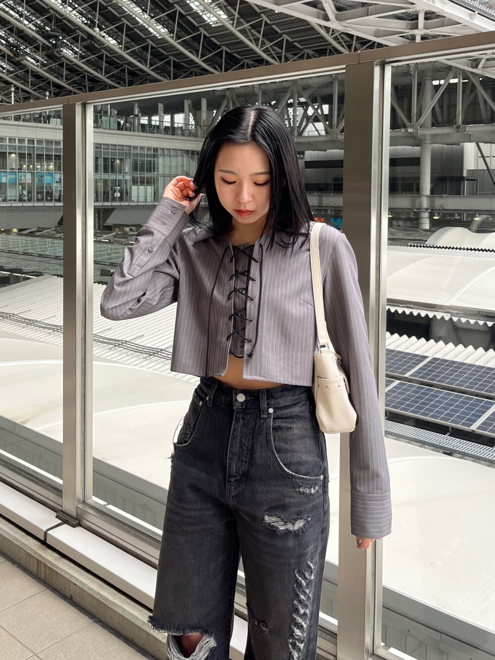 グレー系のシャツ/ブラウス、ブラック系のデニムパンツ、ブラック系のサンダルを着用したレディースの春コーディネートの4枚目の写真